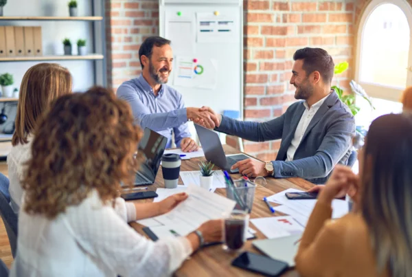 Two men in a conference room shaking hands